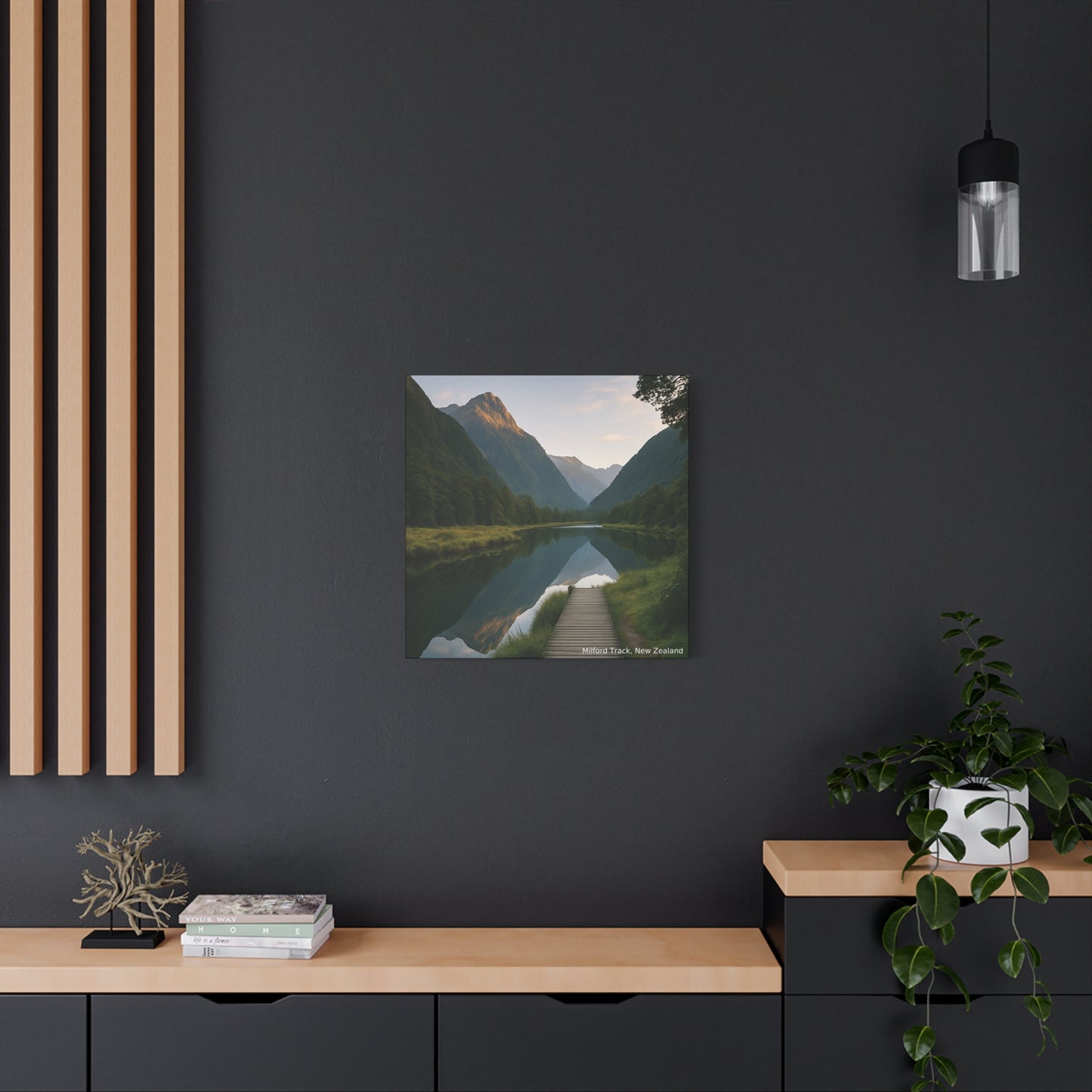 Framed landscape print of a mountain lake on a dark wall with wooden shelves and decor.