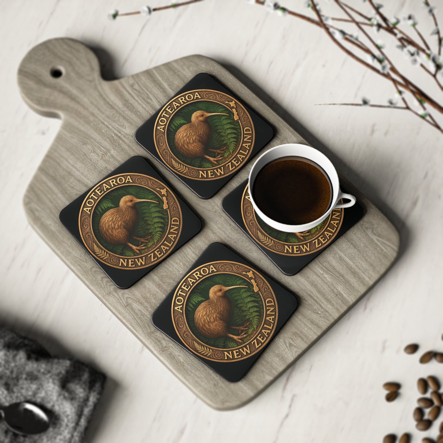 Set of four coasters with kiwi bird design on a wooden tray with a cup of coffee.