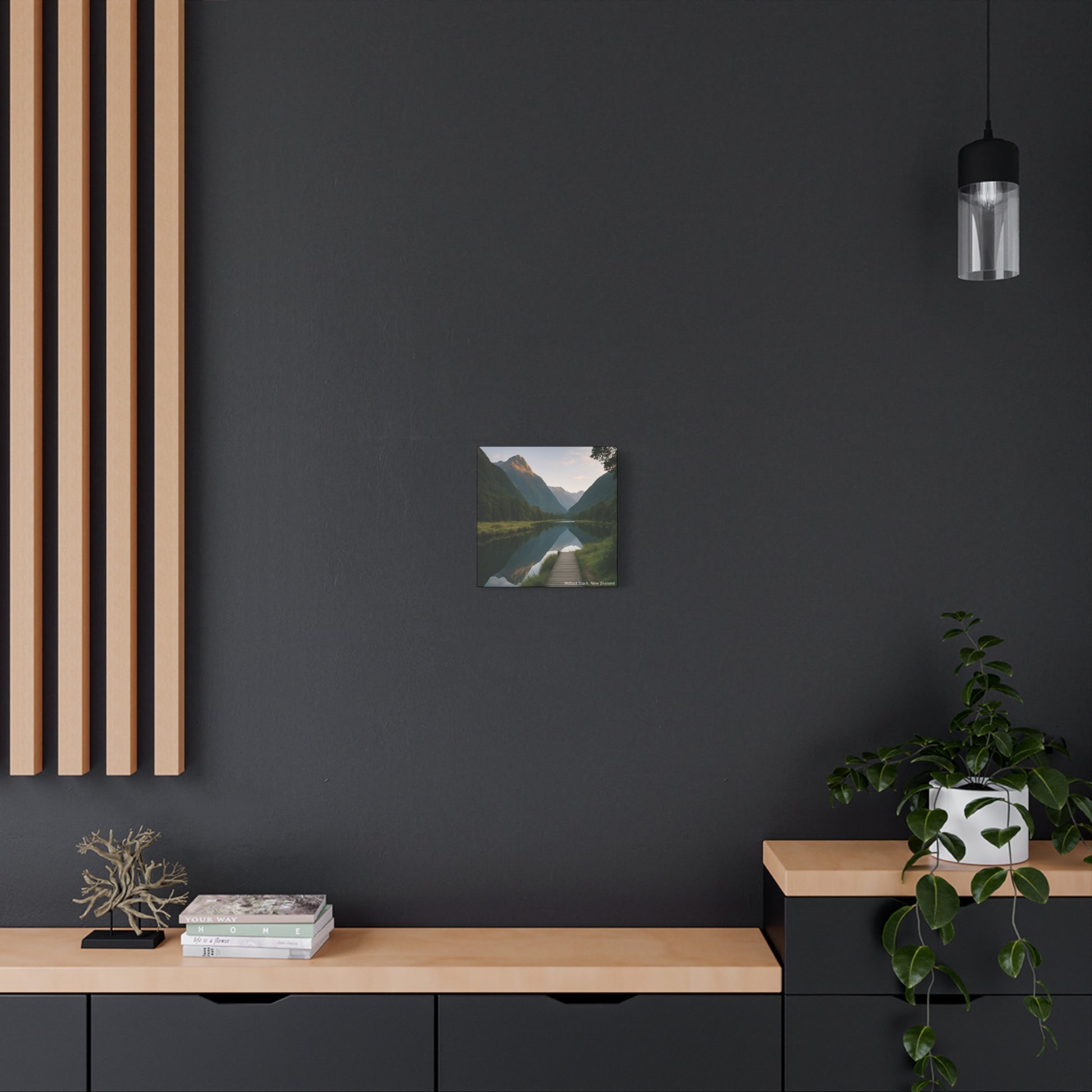 Modern interior with a dark wall, wooden shelf, and framed Milford Track landscape print.
