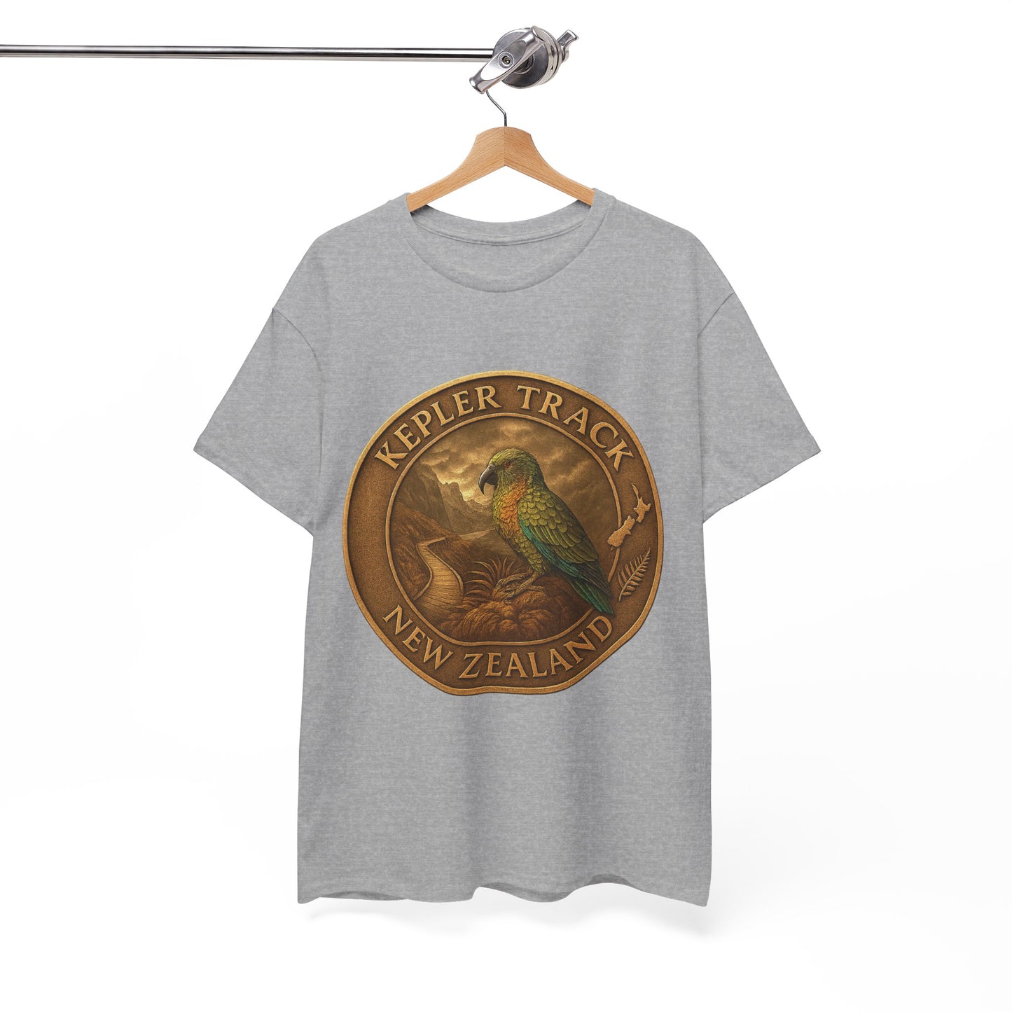 Gray t-shirt with a gold emblem featuring a parrot and 'Kepler Track New Zealand' text on a hanger.