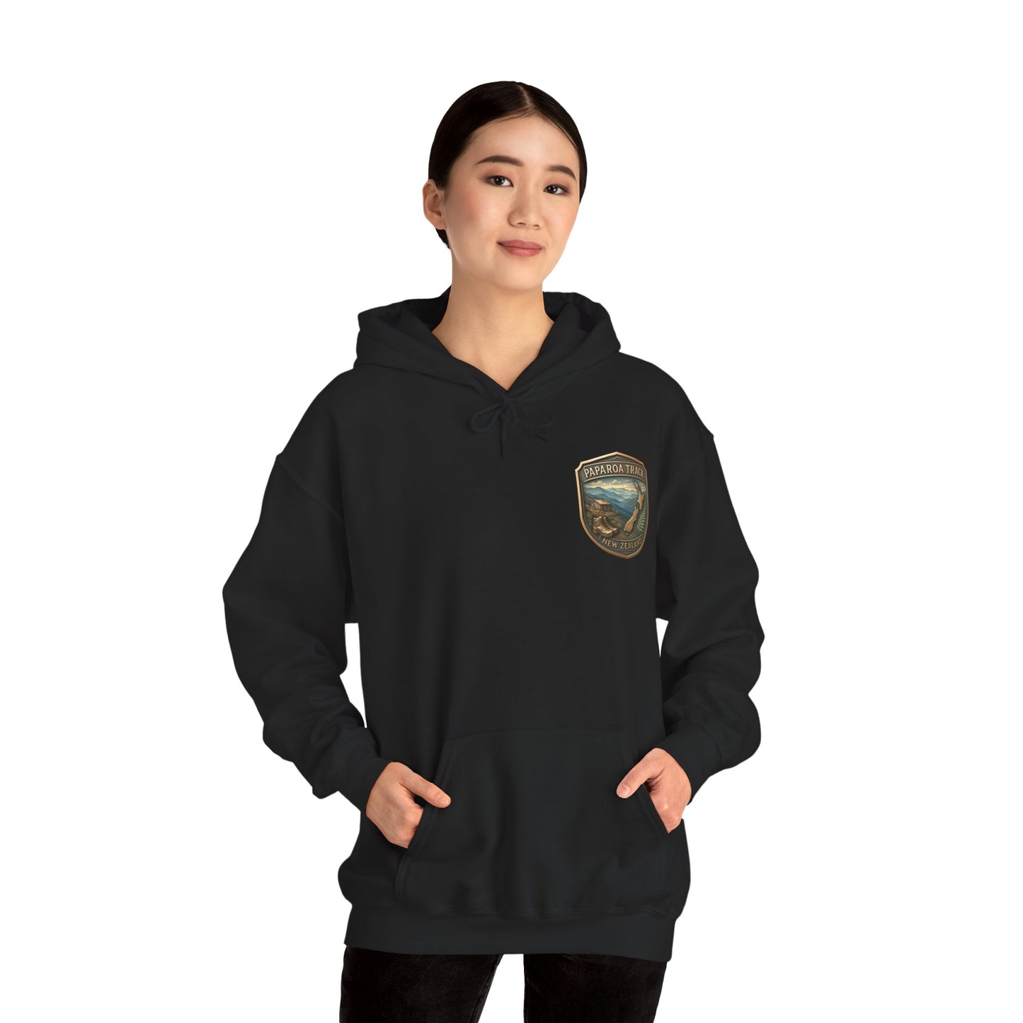 Person wearing a black Paparoa Track hoodie with a logo on a white background
