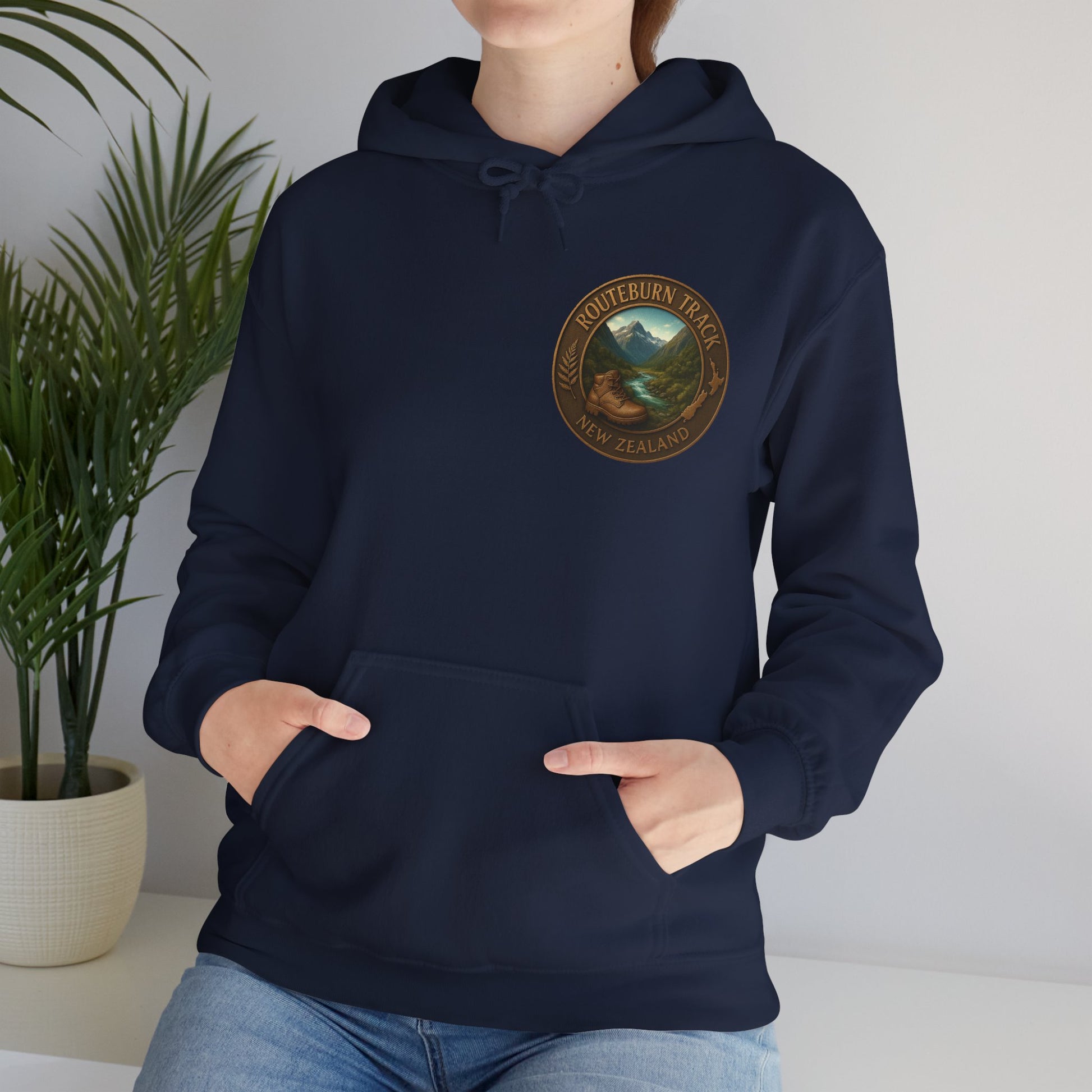 Person wearing a navy blue Routeburn Track hoodie with a logo on a plain background