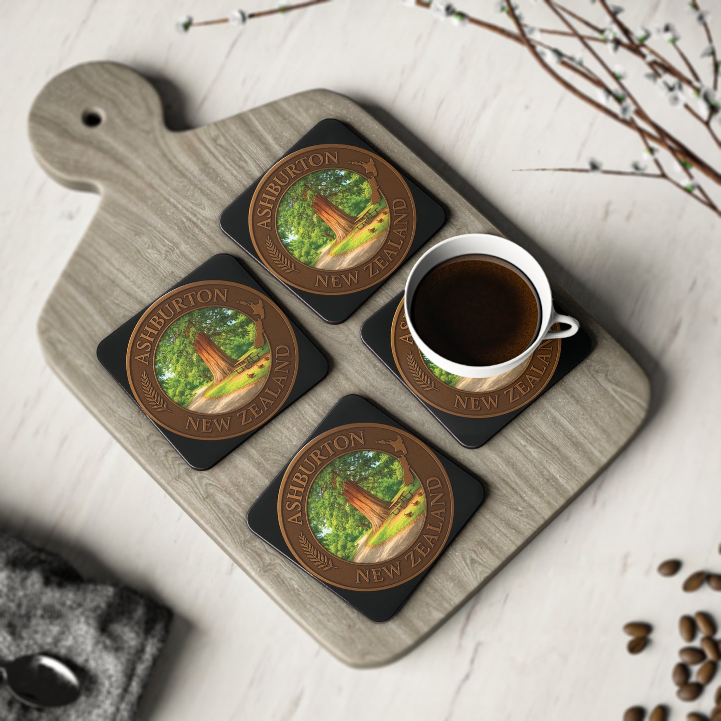 Coasters with a tree design on a wooden board with a cup of coffee.