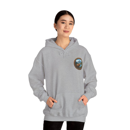 Person wearing a gray hoodie with a New Zealand logo on a white background