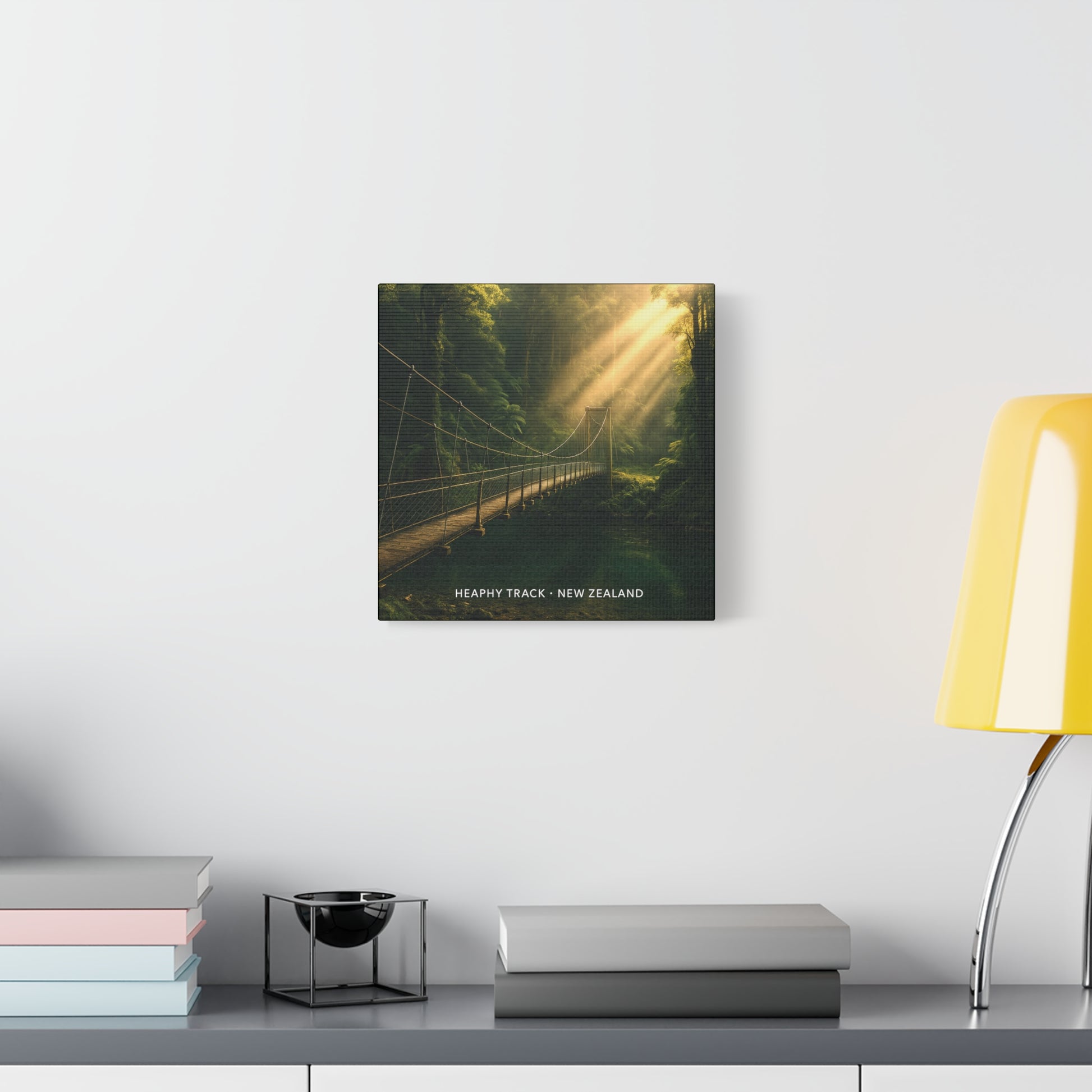 Heaphy Track Canvas print of a forest scene with a suspension bridge, displayed on a wall above a desk.