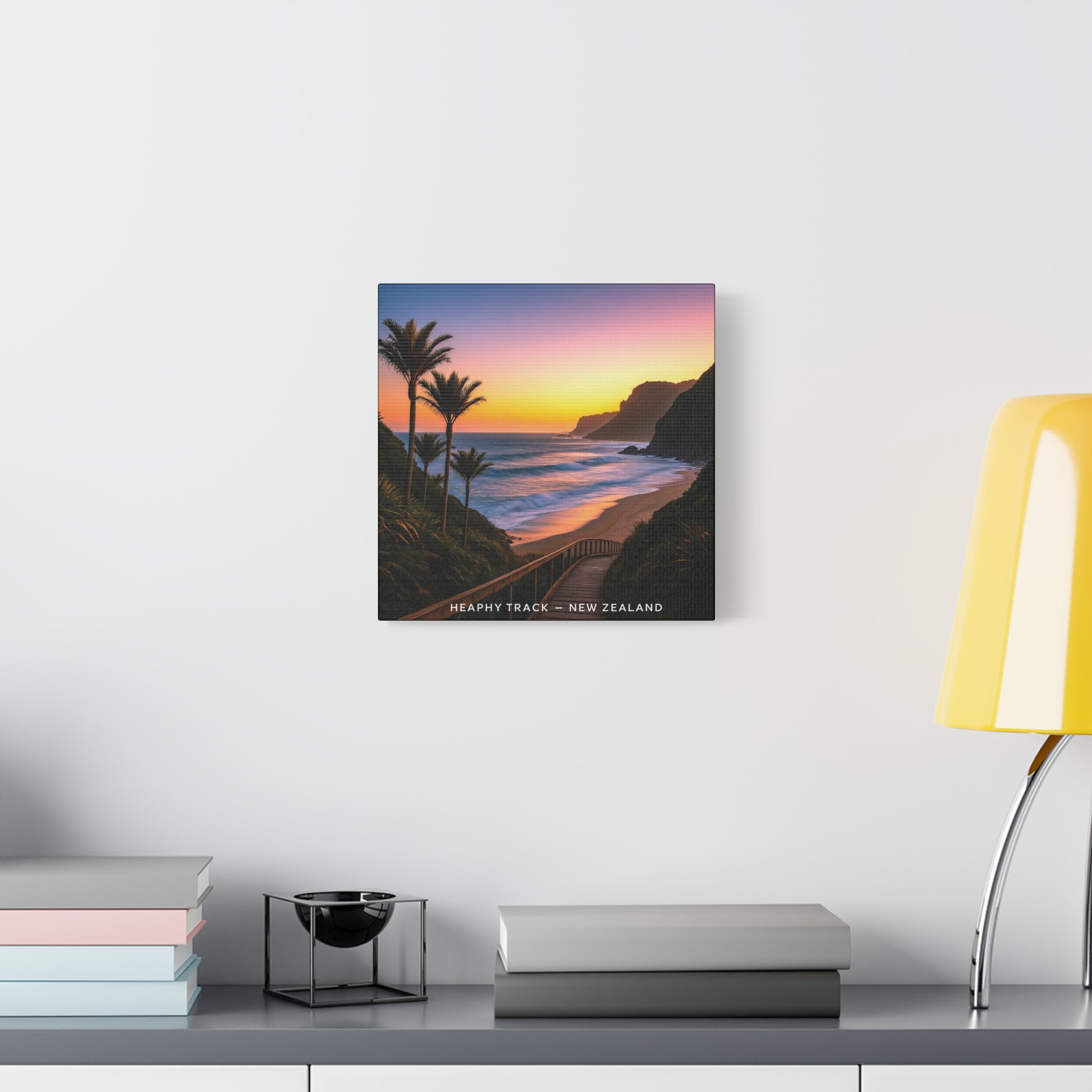 Heaphy Track Framed artwork of a beach scene with palm trees and sunset on a wall above a desk.