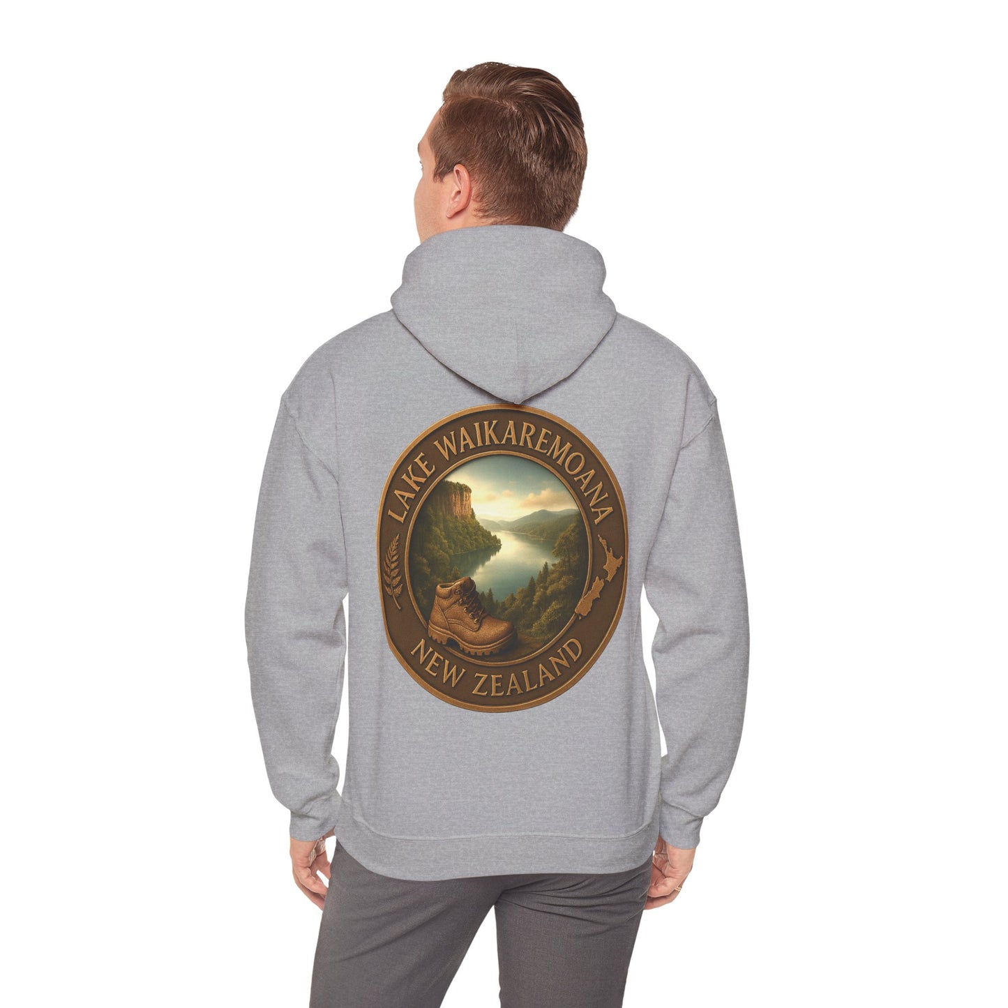 Person wearing a gray Lake Waikaremoana Track hoodie with a scenic design on the back, set against a white background