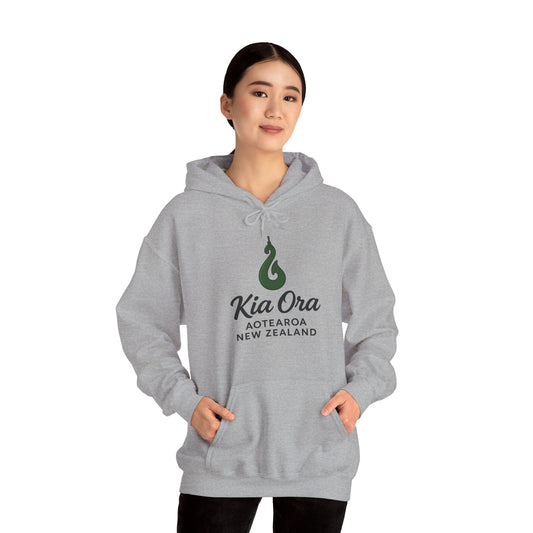 Person wearing a gray hoodie with a green KiaOra New Zealand logo and text on a white background