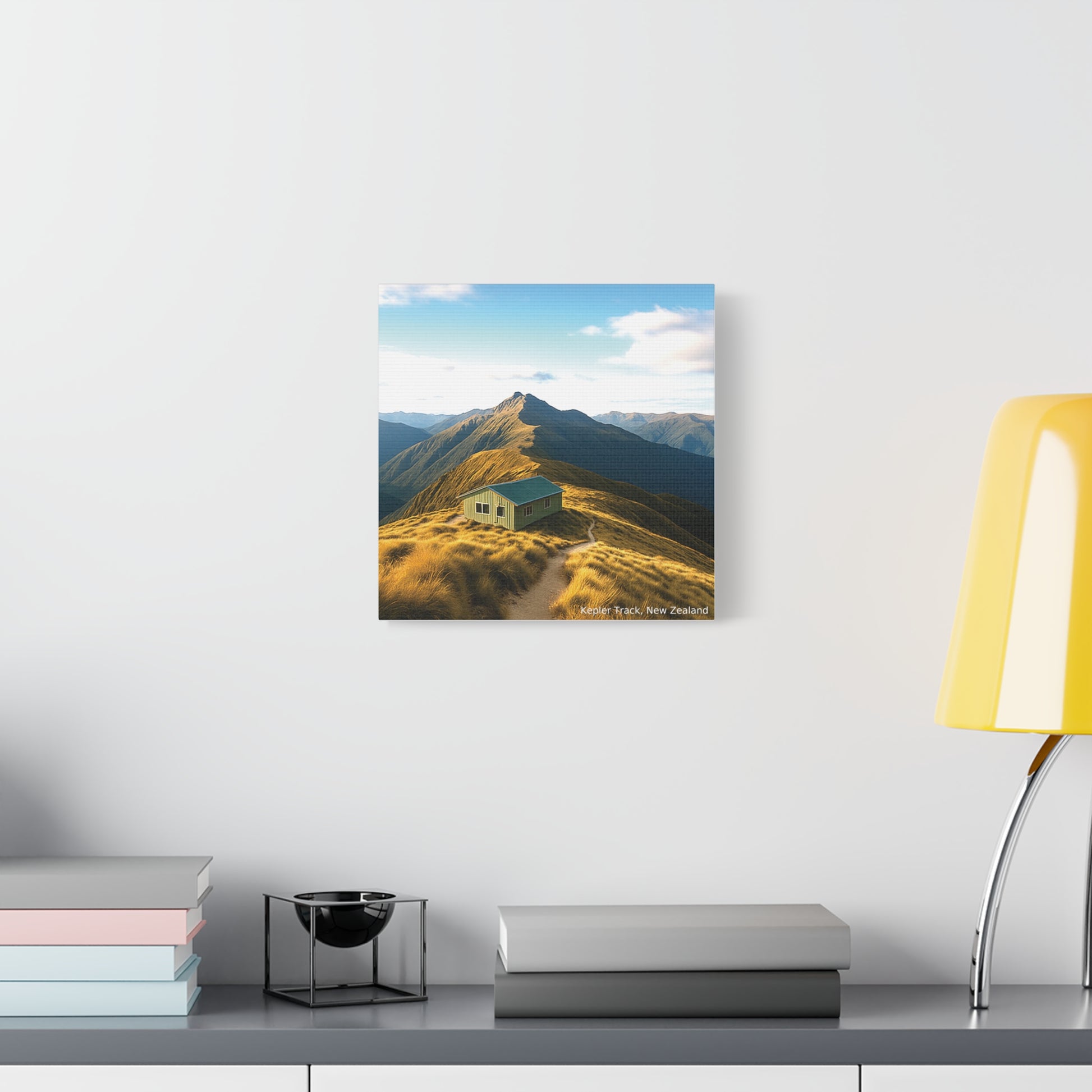 Kepler Track Canvas print of a mountain landscape with a cabin on a white wall above a desk.