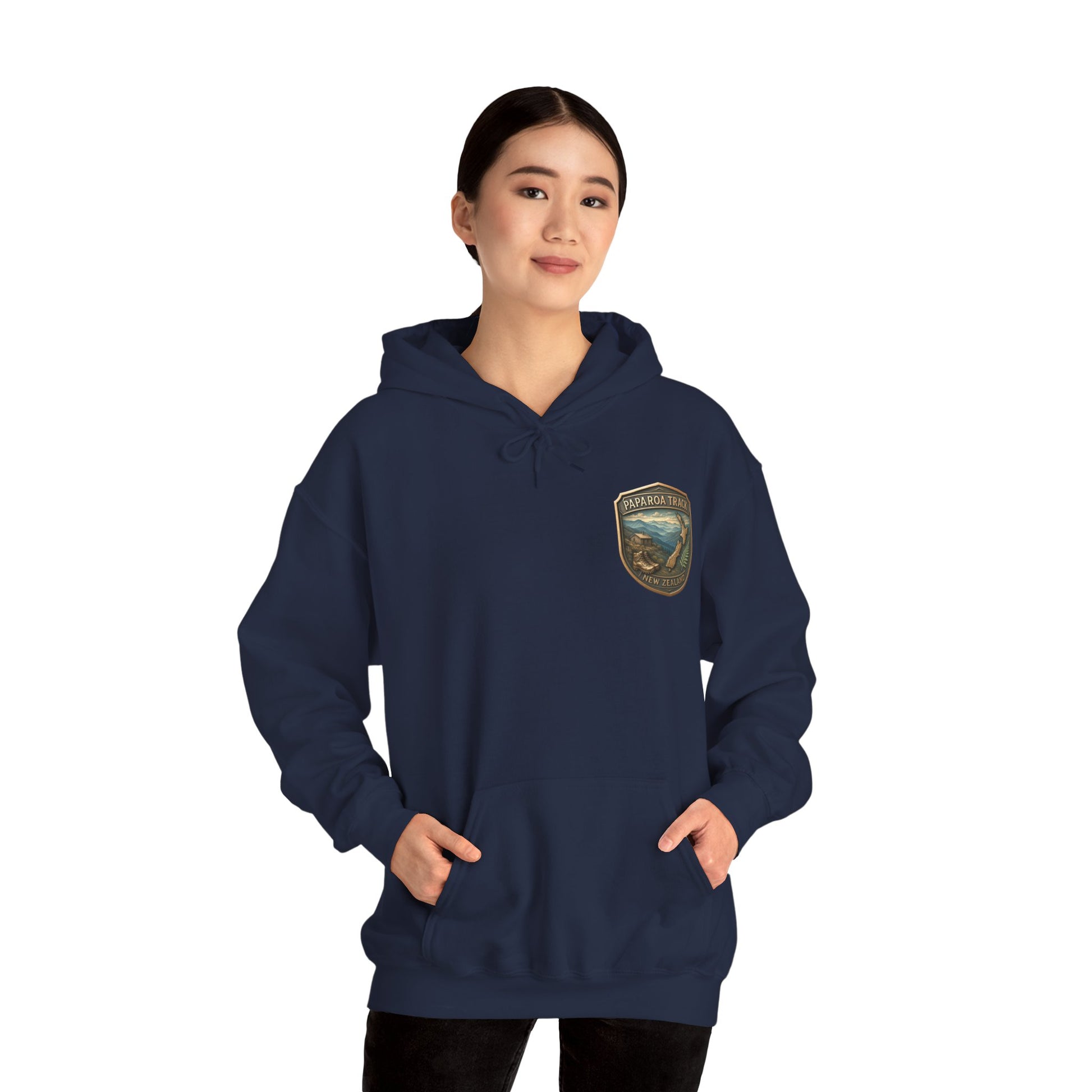Person wearing a navy blue Paparoa Track hoodie with a logo on a white background